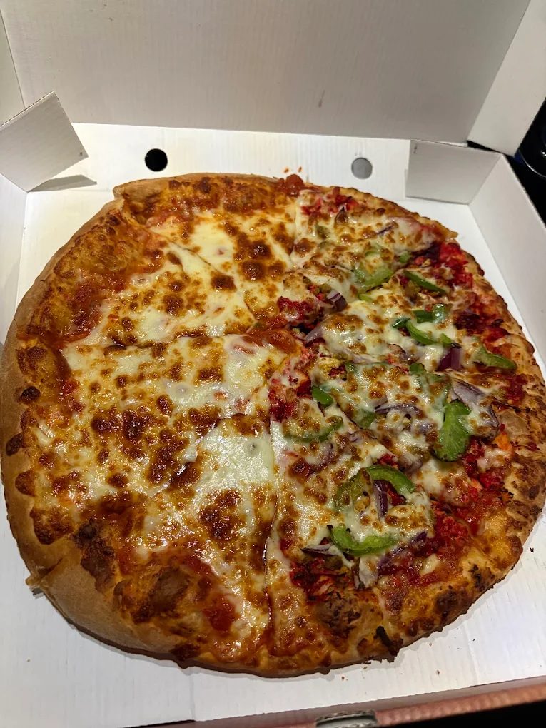 Half cheese, half chicken tikka and pepper pizza in a takeaway box
