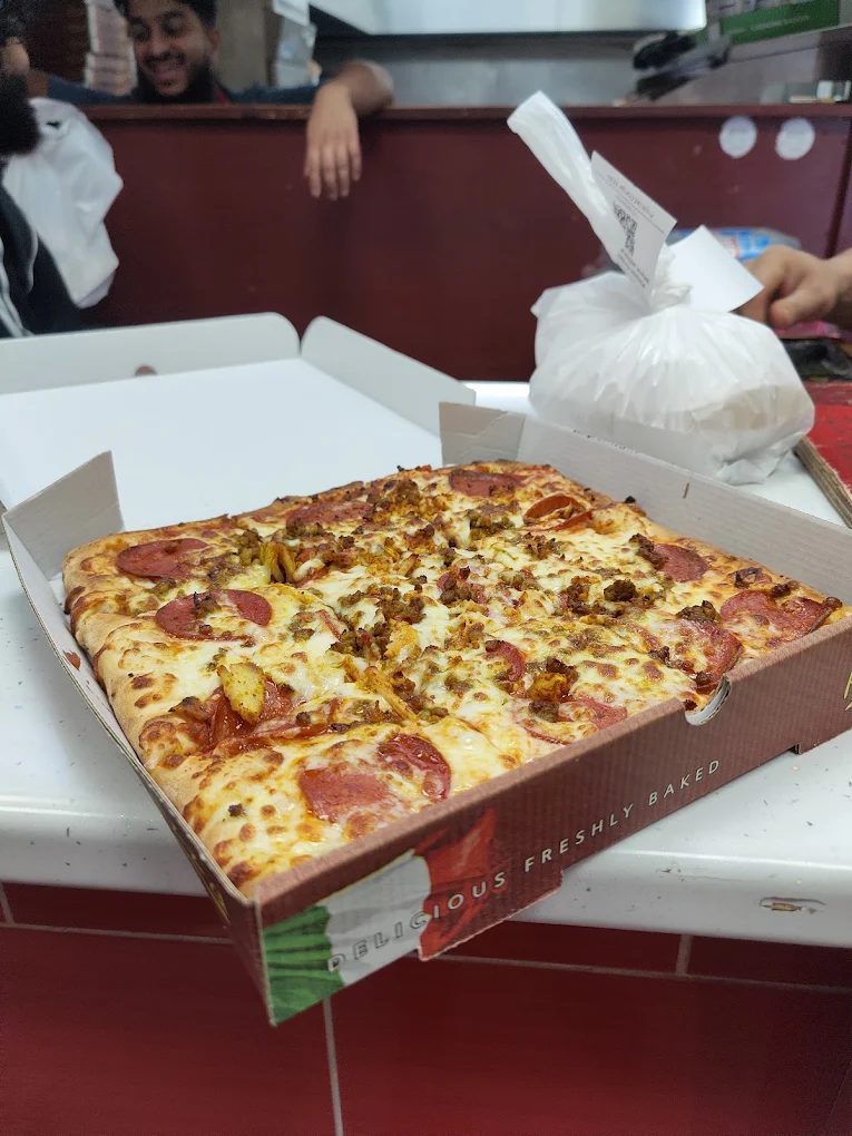 Pepperoni and chicken pizza fresh out of the oven at the counter