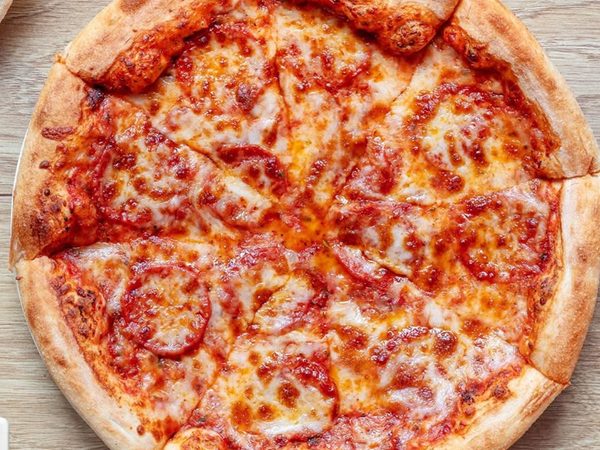 Freshly baked pepperoni pizza cut into slices