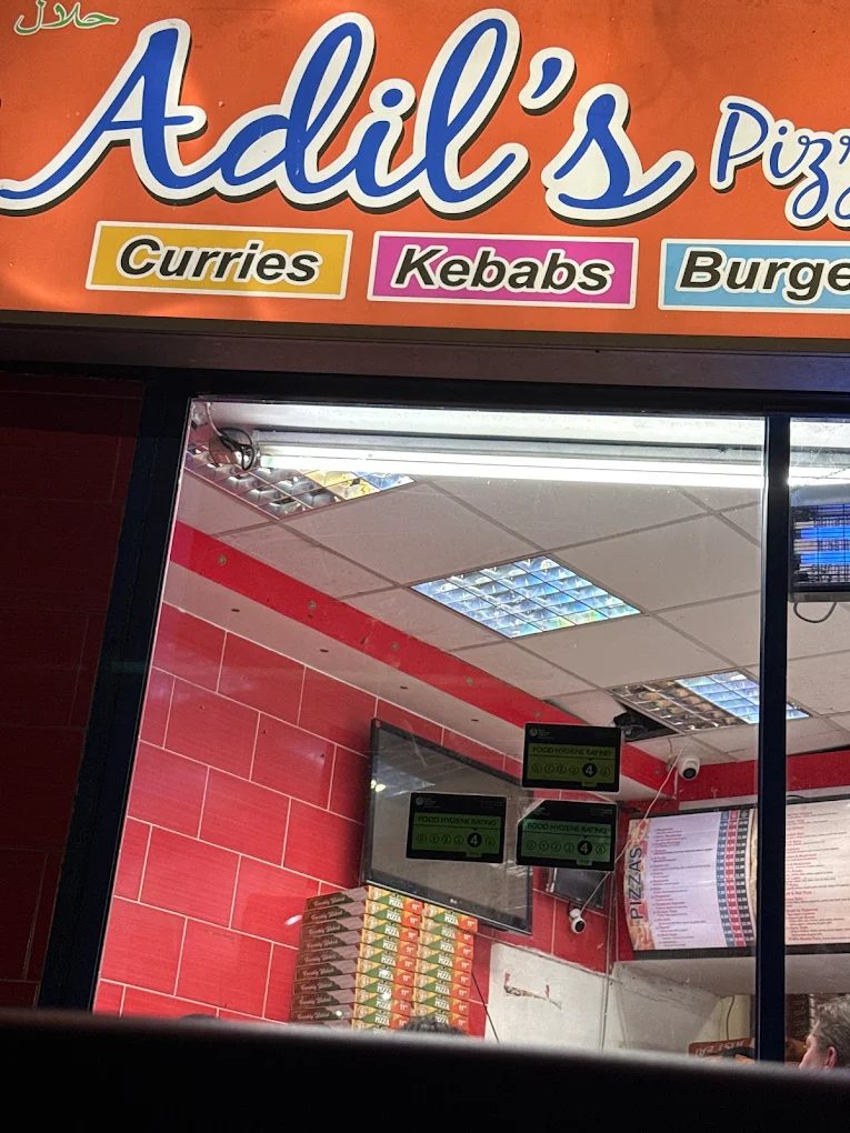 Adil's Pizza shop front on Burley Street, Leeds, lit up at night